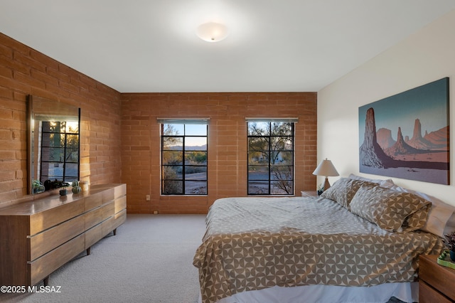 bedroom with brick wall and light colored carpet