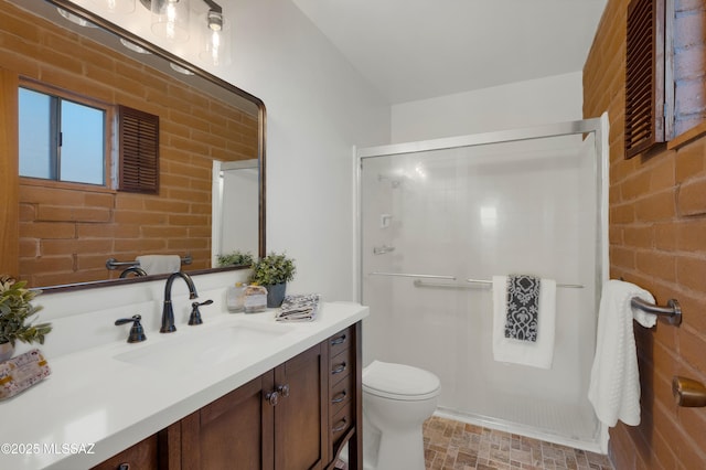 full bath with toilet, brick wall, a shower stall, and vanity