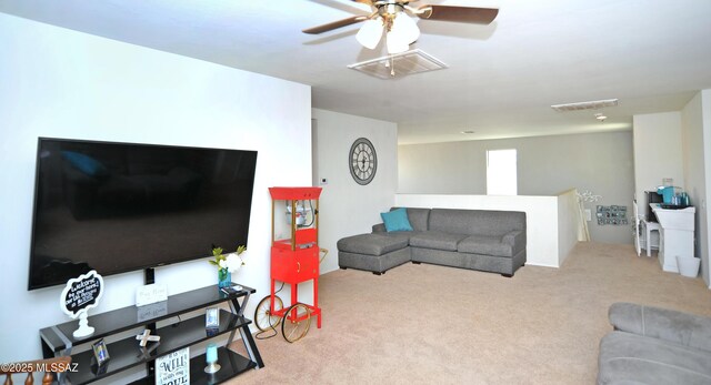 living room featuring carpet floors, visible vents, and ceiling fan