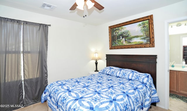 bedroom with light carpet, ceiling fan, visible vents, and ensuite bathroom