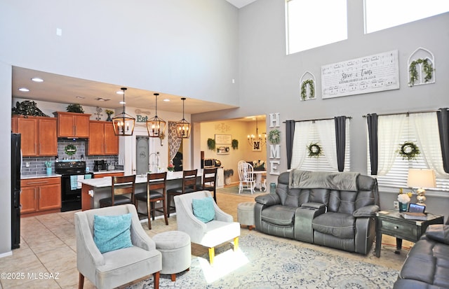 living room featuring recessed lighting, a healthy amount of sunlight, a notable chandelier, and light tile patterned flooring