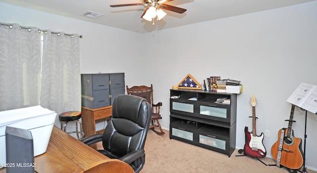 carpeted office with a ceiling fan and visible vents