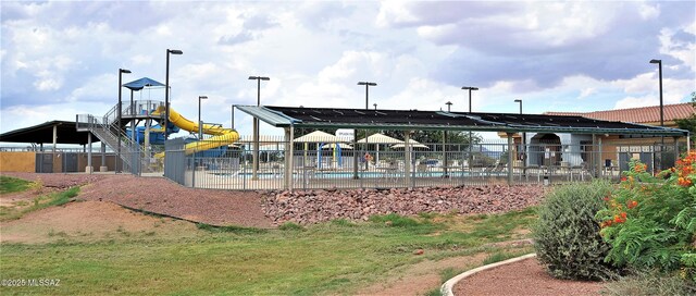 view of home's community with playground community and fence