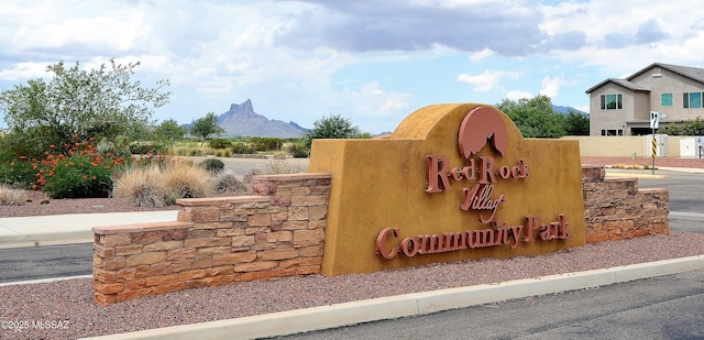 community / neighborhood sign with a mountain view