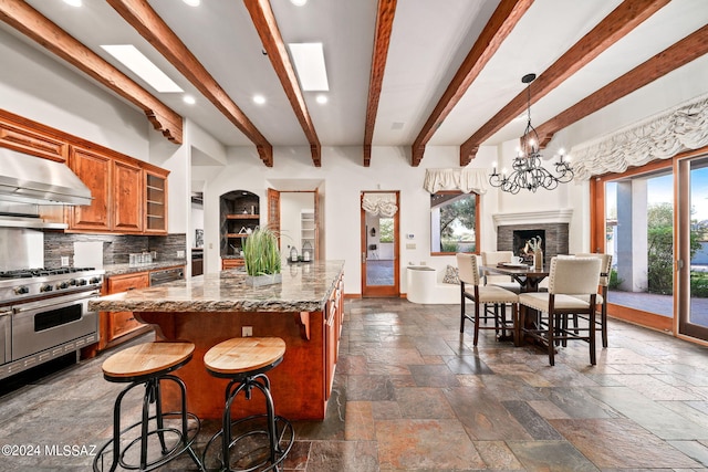 kitchen featuring stone tile floors, glass insert cabinets, dark stone countertops, double oven range, and extractor fan