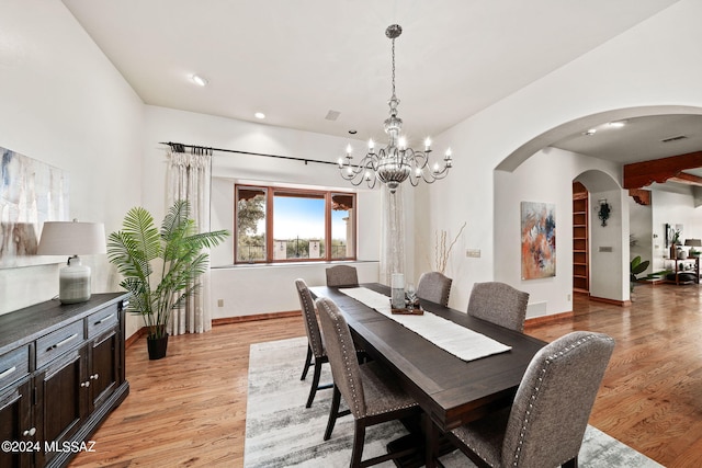 dining room with light wood finished floors, baseboards, visible vents, arched walkways, and recessed lighting