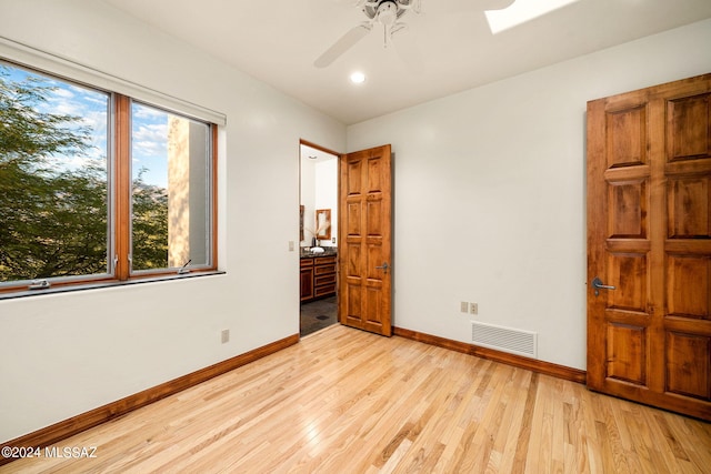 unfurnished bedroom featuring light wood-type flooring, baseboards, visible vents, and ceiling fan