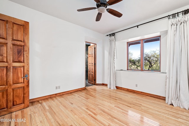 unfurnished bedroom with light wood-type flooring, ceiling fan, and baseboards