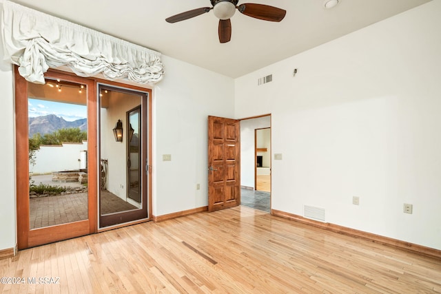 empty room featuring visible vents, baseboards, and wood finished floors