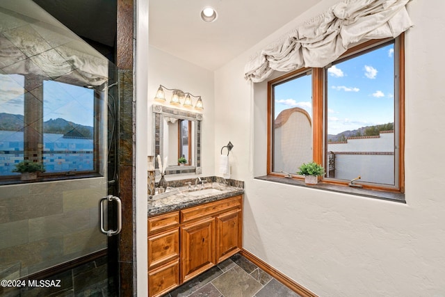 full bathroom featuring stone tile floors, recessed lighting, a stall shower, vanity, and baseboards