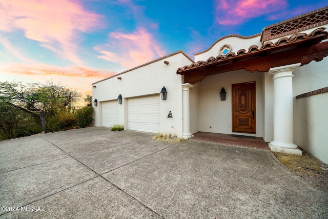 view of front facade featuring driveway, an attached garage, and stucco siding