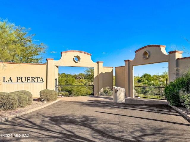 view of road with curbs and a gated entry