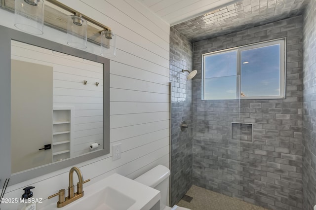 bathroom featuring tiled shower, vanity, and toilet