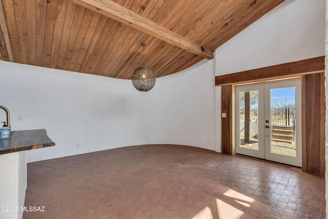 unfurnished room featuring lofted ceiling with beams, wooden ceiling, and french doors