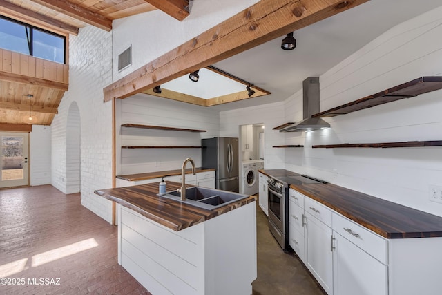 kitchen featuring open shelves, stainless steel appliances, white cabinets, a sink, and washer / dryer