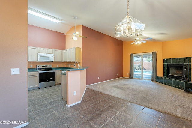 kitchen featuring decorative light fixtures, white microwave, open floor plan, white cabinets, and stainless steel electric range