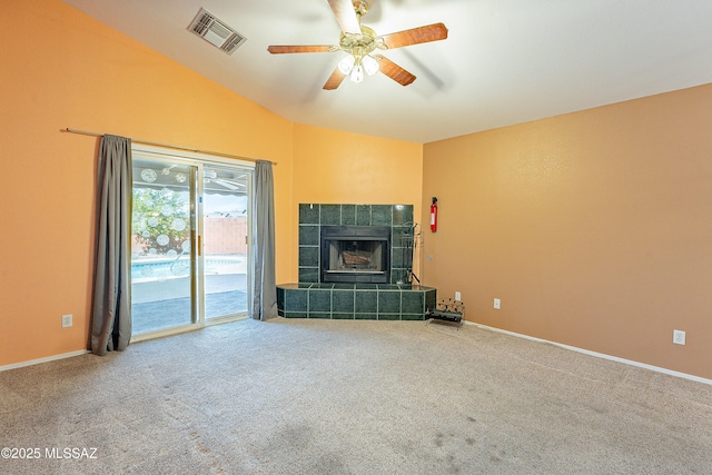 unfurnished living room featuring carpet floors, lofted ceiling, visible vents, a tile fireplace, and baseboards