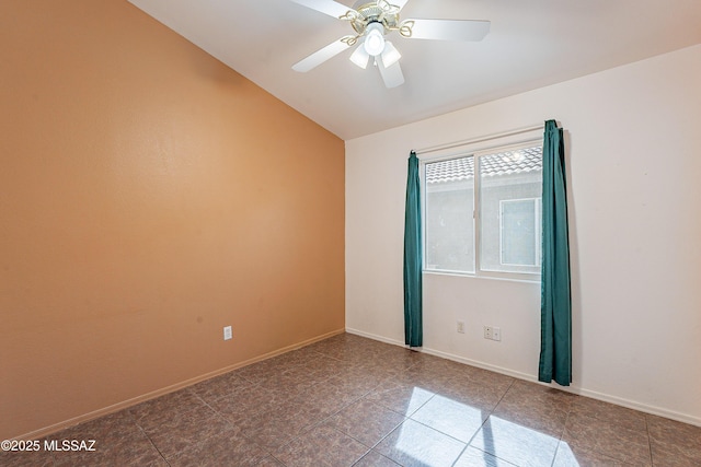 tiled empty room with baseboards, vaulted ceiling, and a ceiling fan