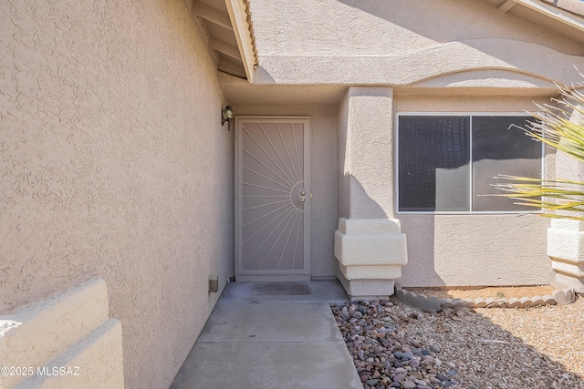 entrance to property featuring stucco siding