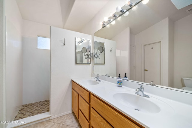 full bath with double vanity, tile patterned flooring, toilet, and a sink