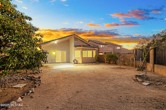 exterior space with a fenced backyard, a tile roof, a patio, and stucco siding