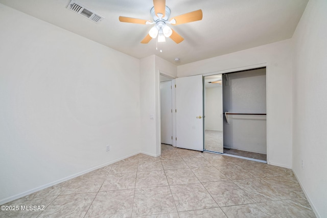 unfurnished bedroom featuring ceiling fan, light tile patterned floors, visible vents, and baseboards