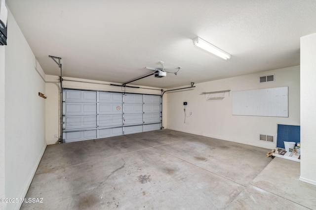 garage with baseboards, visible vents, and a garage door opener
