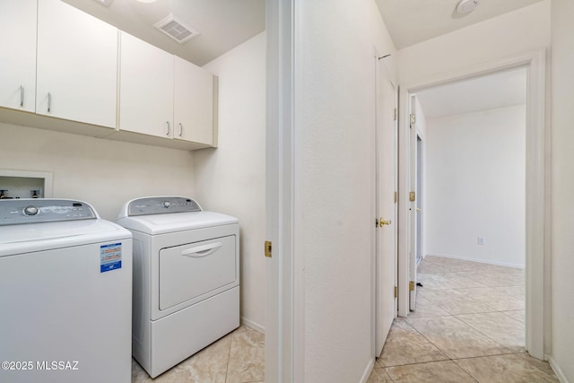 laundry area with light tile patterned flooring, separate washer and dryer, visible vents, baseboards, and cabinet space