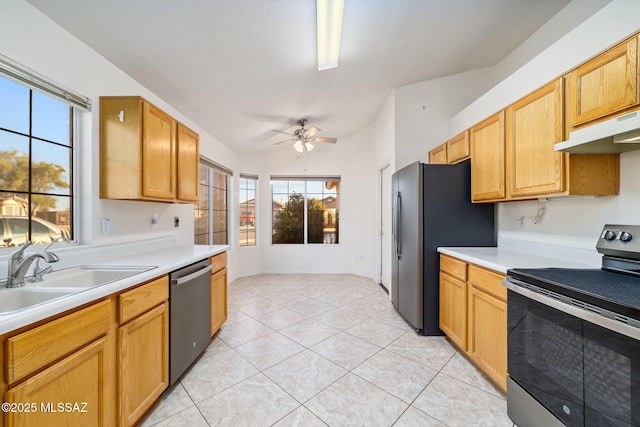 kitchen with light tile patterned floors, appliances with stainless steel finishes, light countertops, under cabinet range hood, and a sink