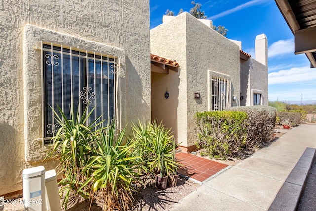 exterior space featuring a tiled roof and stucco siding