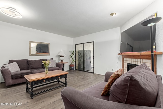 living room featuring wood finished floors and a tile fireplace