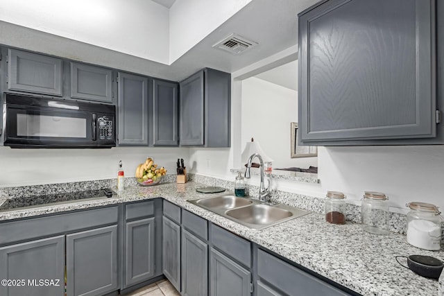 kitchen with black appliances, visible vents, a sink, and gray cabinetry