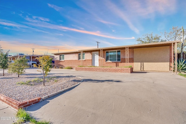 single story home featuring driveway and brick siding