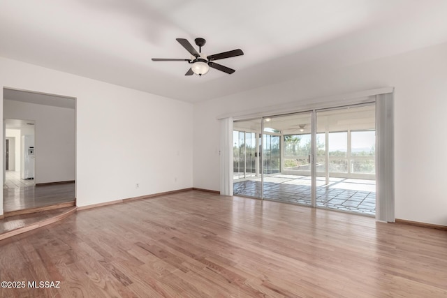 empty room featuring baseboards, a ceiling fan, and light wood-style floors