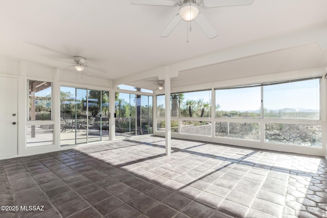 unfurnished sunroom featuring a ceiling fan