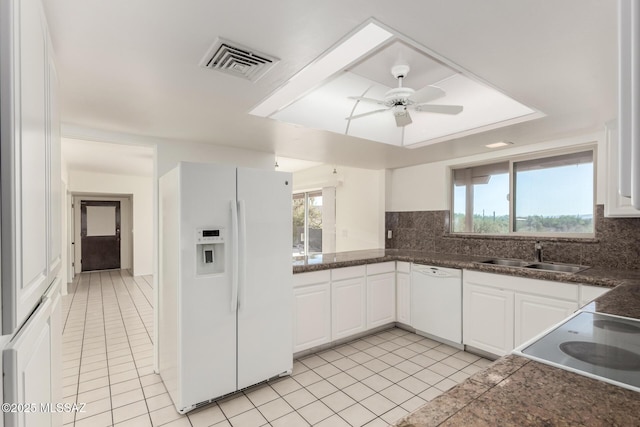 kitchen featuring visible vents, backsplash, white cabinetry, a sink, and white appliances