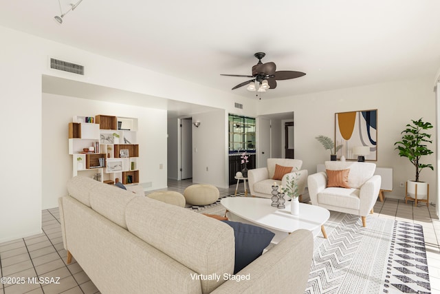 living area featuring tile patterned flooring, visible vents, and ceiling fan