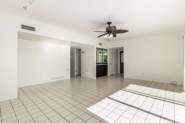 empty room with light tile patterned floors, visible vents, and a ceiling fan