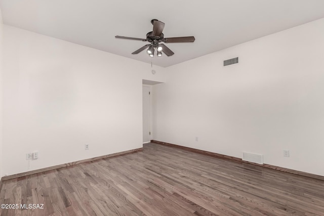 unfurnished room with baseboards, wood finished floors, visible vents, and a ceiling fan