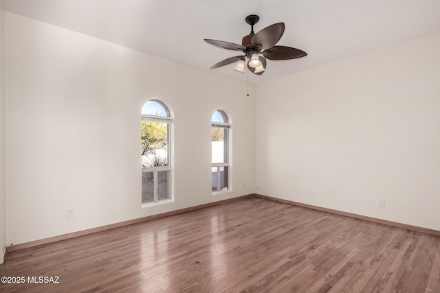 spare room with light wood-style floors, baseboards, and a ceiling fan