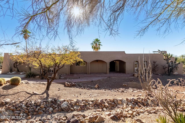 pueblo-style house with a patio and stucco siding