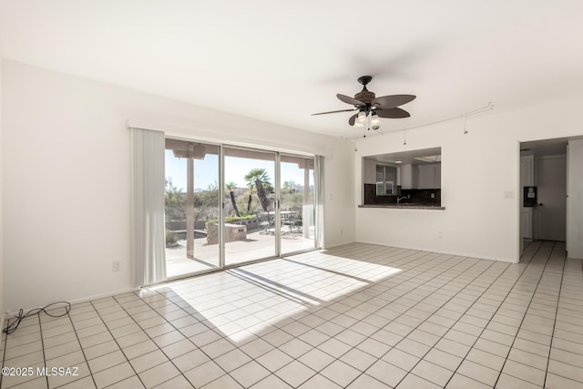 unfurnished living room with light tile patterned floors, a ceiling fan, and baseboards