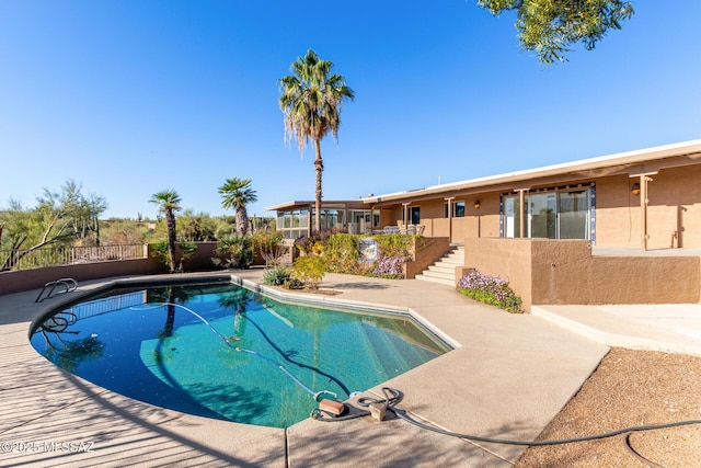 view of swimming pool featuring stairs, fence, a fenced in pool, and a patio