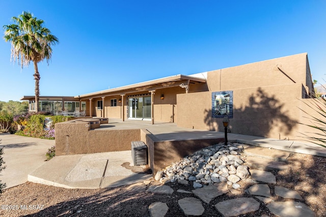 back of property featuring a patio area and stucco siding