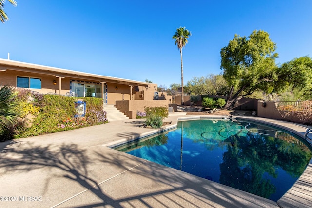 view of pool featuring a fenced in pool, a patio area, fence, and stairs