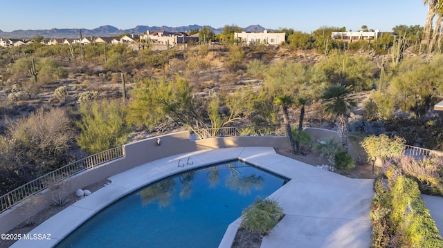 view of swimming pool with a fenced in pool, a residential view, fence, a patio area, and a mountain view