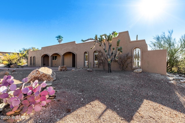 pueblo revival-style home with stucco siding