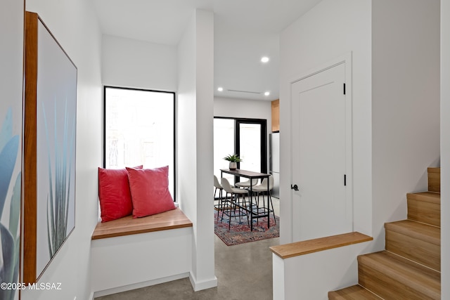 interior space featuring recessed lighting, finished concrete flooring, and stairs