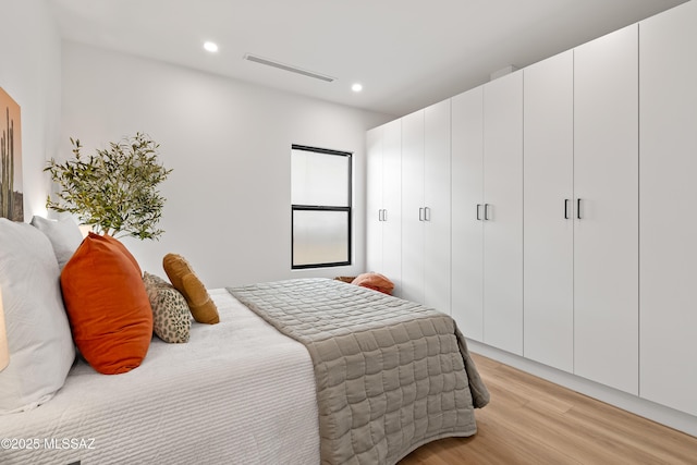 bedroom with light wood-type flooring, visible vents, and recessed lighting