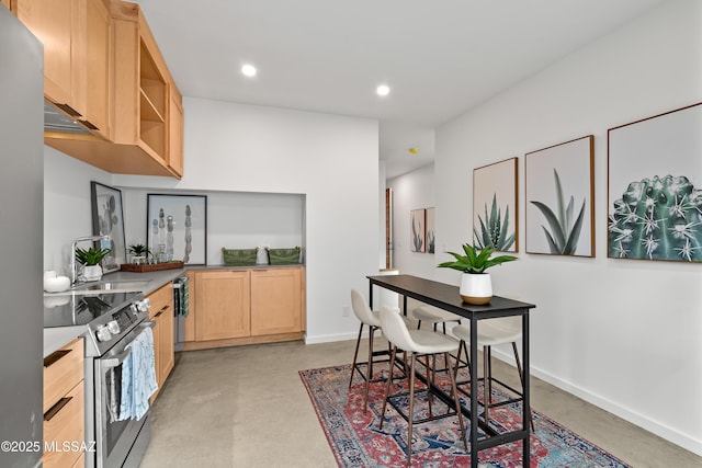 kitchen featuring recessed lighting, stainless steel appliances, baseboards, finished concrete flooring, and light brown cabinetry